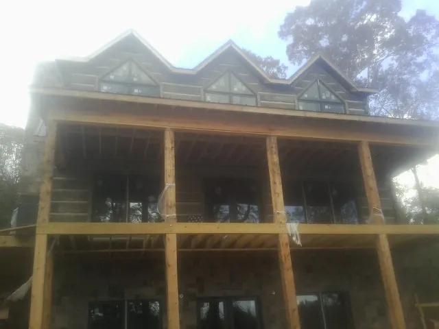 Dormers and porch framing on a large log home under construction — Roof Coating work by our crew in Sparrows Point