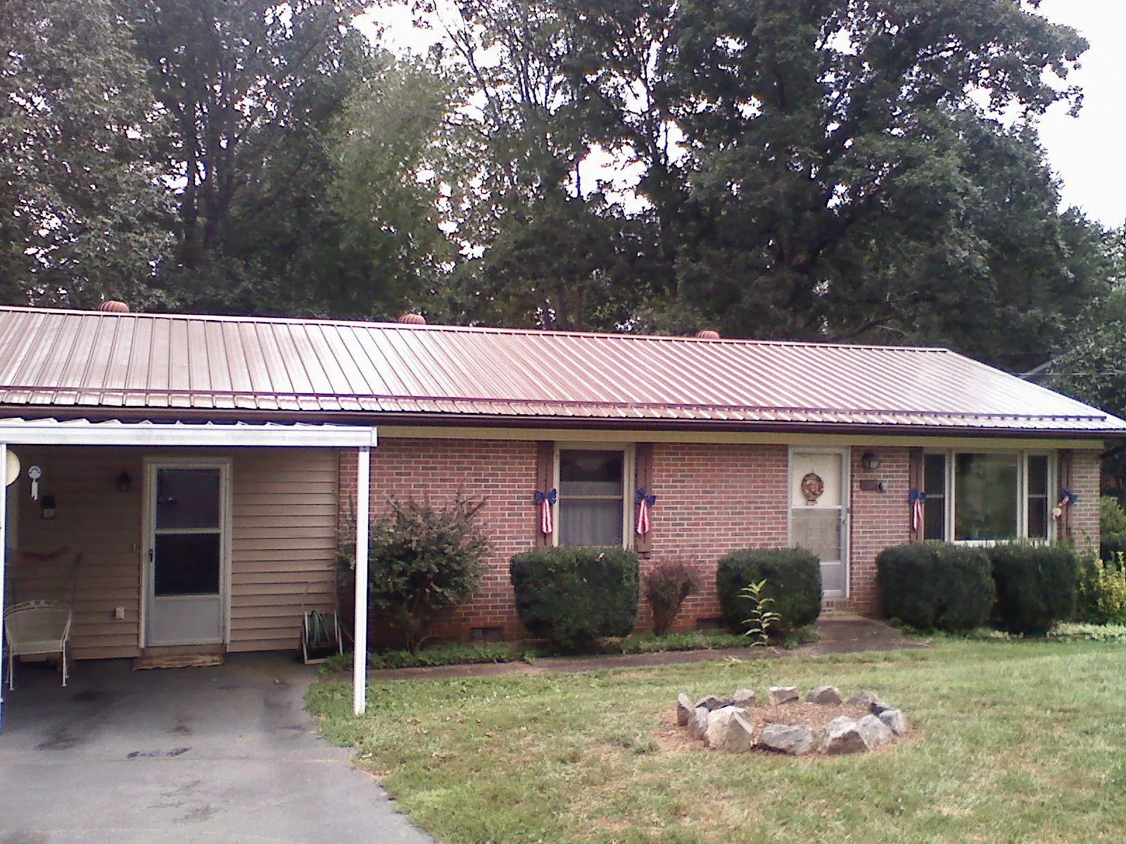 Bronze metal roof and carport on a brick ranch home — Roof Repair work by our crew in Sparrows Point